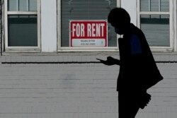 FILE - A man walks in front of a For Rent sign in a window of a residential property in San Francisco, Oct. 20, 2020.