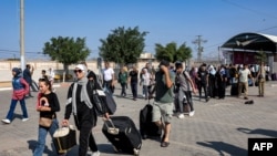 People enter the Rafah border crossing in the southern Gaza Strip before crossing into Egypt on Nov. 1, 2023.