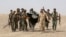 FILE - G-7 leaders are expected to discuss efforts to defeat the Islamic State. Here, Iraq's Shi'ite paramilitaries and Iraqi security forces hold an Islamist State flag pulled down in Anbar province, May 26, 2015.