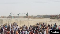 People gather and wait to welcome their relatives arriving from Afghanistan, at the Friendship Gate crossing point at the Pakistan-Afghanistan border town of Chaman, Pakistan, Aug. 17, 2021.