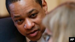 Virginia Lt. Gov. Justin Fairfax, left, listens to assistant Senate Clerk, Tara Perkinson, as he prepares to preside over the Senate at the Capitol in Richmond, Virginia, Feb. 4, 2019. 