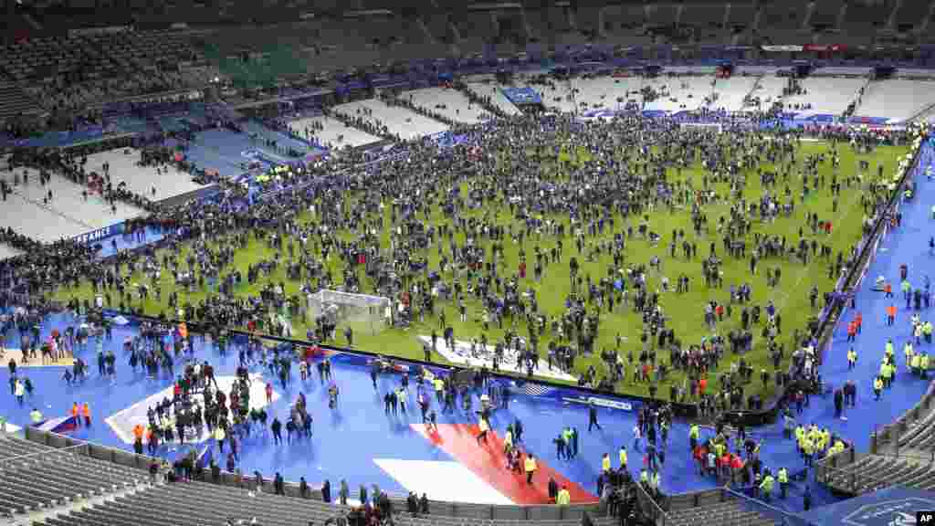Après que trois explosions ont retenti aux abords du Stade de France vendredi 13 novembre 2015, les spectateurs ont envahi le terrain en attendant d'être évacués en toute sécurité. &nbsp;