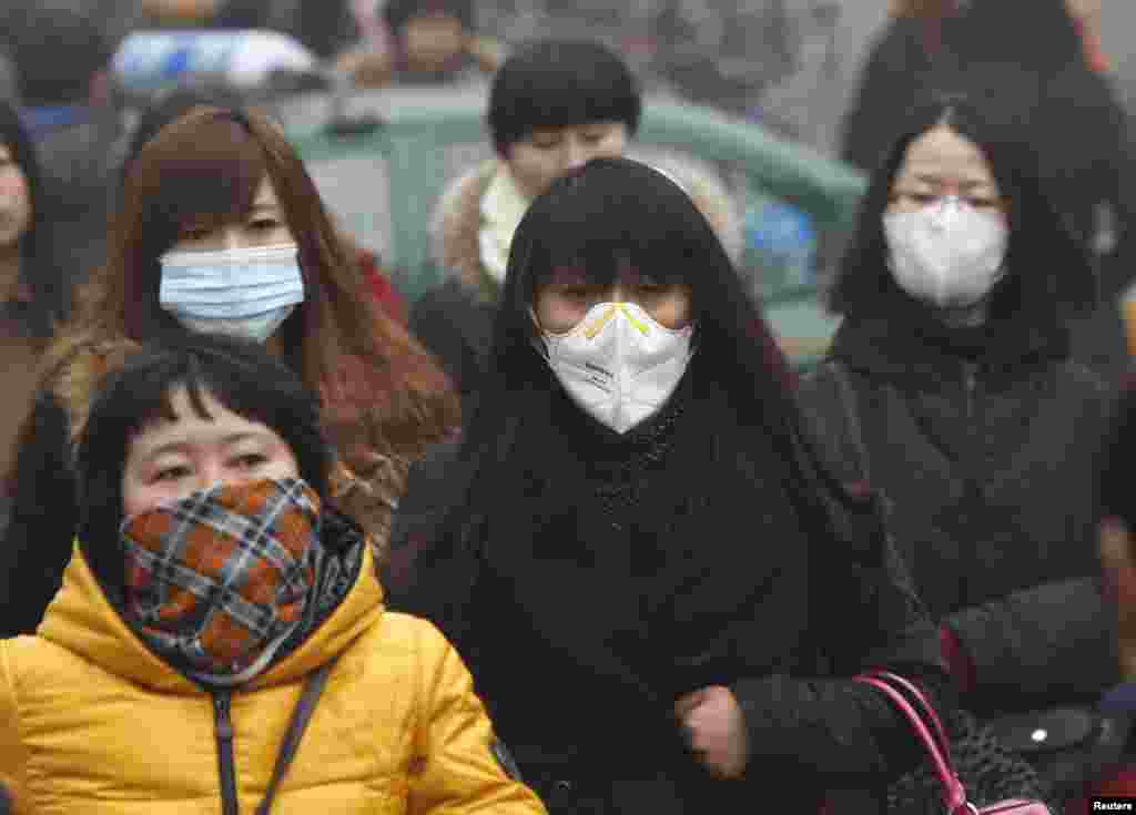 Commuters wearing masks make their way amid thick haze in the morning in Beijing, Feb. 26, 2014.&nbsp;