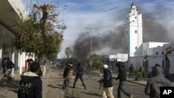 Demonstrators clashing with riot police in a street of Regueb, 09 Jan 2011.