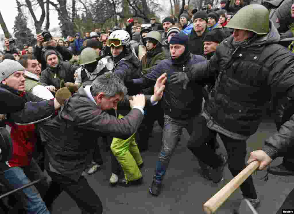 Para demonstran anti-pemerintah menyerang wakil ketua Partai Daerah Vitaly Grushevsky (kedua dari kiri, depan) di luar gedung Parlemen Ukraina di Kyiv.&nbsp;
