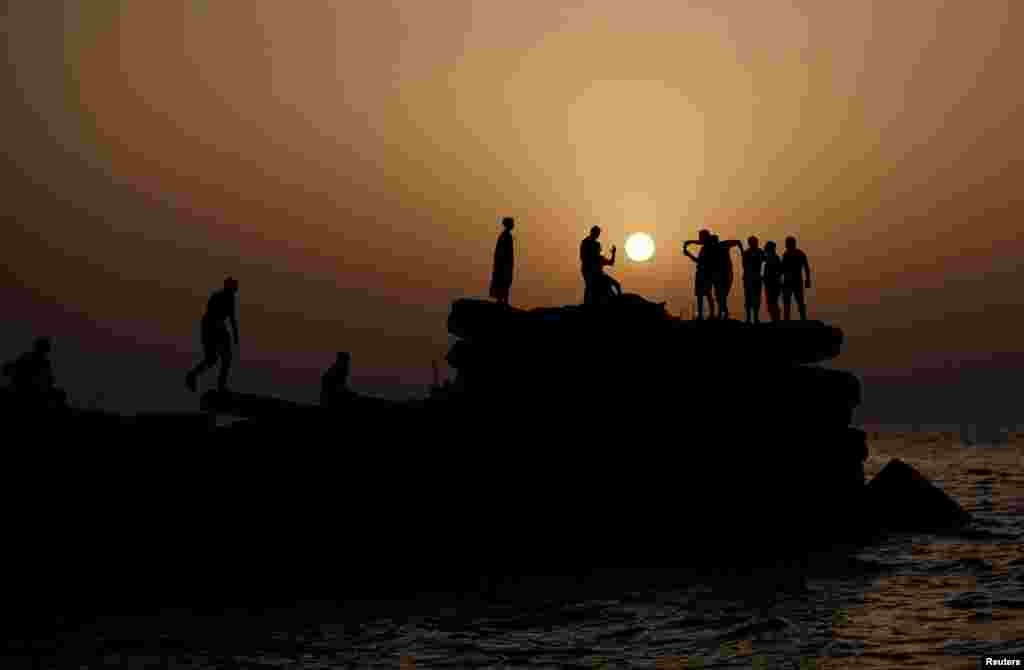 ជនជាតិ​ប៉ាឡេស្ទីន​​កំពុង​​ឈរ​នៅ​លើ​កំពង់​ផែរ​អំឡុង​ព្រះអាទិត្យ​លិច​នៅ​ទីក្រុង​ហ្គាហ្សា។