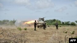 This handout picture released by the AU-UN Information Support Team shows Ugandan soldiers, part of the African Union Mission in Somalia, firing towards Shabab fighters iin the Lower Shabelle region of Somalia, August 30, 2014. (AFP/AMISOM handout/Tobin Jones)