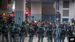Riot police stand guard as lawyer and newly elected district councillor arrive at the Polytechnic University to meet the left-over protesters in Hong Kong, Nov. 25, 2019. 