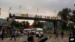 A man jokes with a friend as he sings near a subway station, during the coronavirus pandemic in Mexico City, June 1, 2020. 