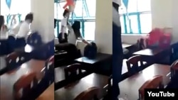 Nhóm nữ sinh dùng ghế nhựa phang liên tiếp vào đầu, đấm túi bụi, kéo và giật tóc một nữ sinh cùng lớp (ngồi) trong khi các em khác đứng xem. (Ảnh từ clip trên YouTube).