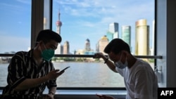 Passengers cross the Huangpu River on a ferry in Shanghai on June 7, 2022, following the easing of Covid-19 restrictions in the city after a two-month lockdown.