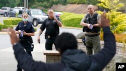 FILE - Ken Westphal, center, an instructor at the Criminal Justice Training Commission in Washington state, works with cadets LeAnne Cone of the Vancouver police and Kevin Burton-Crow of the Thurston County sheriff's office during training, July 14, 2021, in Burien, Wash.
