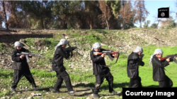 Chilren are seen carrying weapons and performing military drills in this still from an IS video called "Blood of Jihad 2."