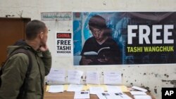 A Tibetan exile in Dharmsala, India, walks past a banner demanding the release of Tashi Wangchuk, an outspoken campaigner for the rights of Tibetans to receive instructions in Tibetan language, who was arrested in 2016 in China's Qinghai province for allegedly inciting separatism, Jan. 27, 2017. 