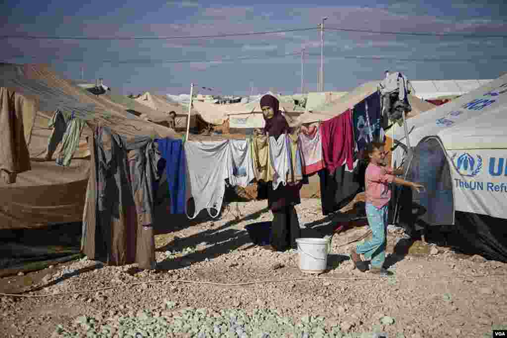 A woman hangs clothes to dry at the Za&#39;tari refugee camp. (Y. Weeks/VOA) 
