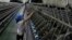 FILE- A woman works at a yarn-weaving plant of the Ha Nam textile company in Phu Ly city, about 60 km (37 miles) south of Hanoi, July 4, 2013. 