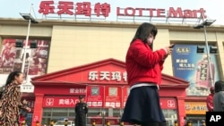 Residents walk past a Lotte Mart where additional security measures are visible in Beijing, China, March 17, 2017. Retail giant Lotte Group, South Korea's No. 5 business group, took the brunt of the backlash after agreeing to let one of its golf courses in southeastern South Korea be a site for deploying the Terminal High-Altitude Area Defense system, or THAAD. At least 55 of 99 Lotte Mart discount stores in China were shut in early March for a month each after surprise inspections found violations of fire safety standards.