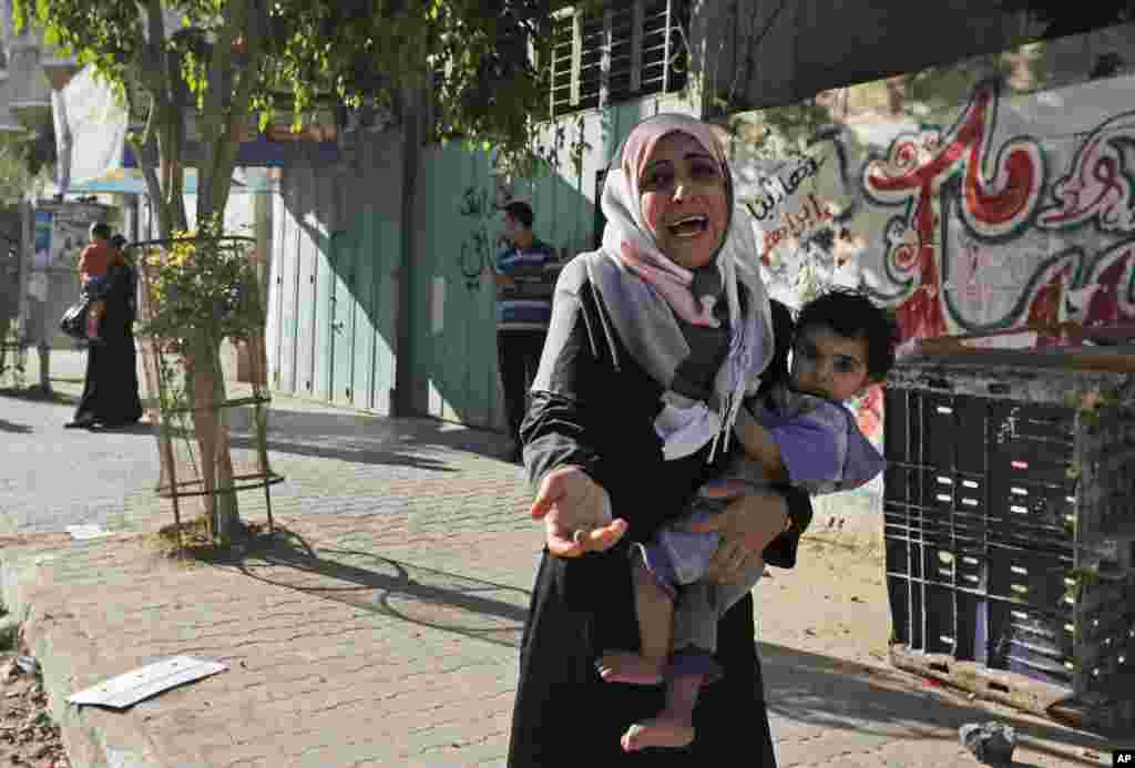 A woman cries as Palestinians flee their homes after Israel airdropped leaflets warning people to leave the area, in the Shajaiyeh neighborhood of Gaza City, July 16, 2014.