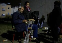 Albanians sit at a makeshift camp in Durres, Nov. 28, 2019, after an earthquake shook Albania.