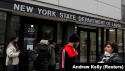 Warga berkumpul di pintu masuk kantor Departemen Tenaga Kerja Negara Bagian New York, yang ditutup untuk umum di tengah pandemi Covid-19 di wilayah Brooklyn, New York, AS, 20 Maret 2020. (REUTERS / Andrew Kelly).