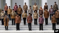 Indonesian President Joko Widodo, front row, center, and his deputy Jusuf Kalla, front row, second right, pose with the newly appointed cabinet ministers after their the inauguration ceremony at the presidential palace in Jakarta, Indonesia, Oct. 27, 2014