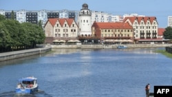 FILE - A man sits on a pole along the river in Kaliningrad on June 18, 2018, during the Russia 2018 World Cup football tournament. 