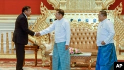 Myanmar State Administration Council Chairman Senior General Min Aung Hlaing, center, shakes hands with Cambodian Foreign Minister and ASEAN Special Envoy to Myanmar Prak Sokhonn, left, and Myanmar FM Wunna Maung Lwin, right, during a meeting in Naypyitaw, Myanmar, June 30, 2022.