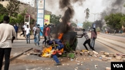 Protesters throw a dumpster on a fire in Dakar, Senegal, June 17, 2022. (Annika Hammerschlag/VOA)