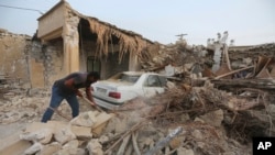 A man cleans up the rubble after an earthquake at Sayeh Khosh village in Hormozgan province, some 620 miles (1,000 kilometers) south of the capital, Tehran, Iran, Saturday, July 2, 2022.