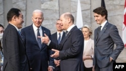 Kanselir Jerman Olaf Scholz (kedua dari kanan, depan) menyapa Perdana Menteri Jepang Fumio Kishida (kiri) dan sejumlah pemimpin negara lainnya dalam pertemuan para anggota NATO di markas aliansi tersebut di Brussels, pada 24 Maret 2022. (Foto: Pool/AFP/Michael Kappeler)