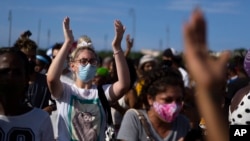 FILE - Anti-government protesters rally against ongoing food shortages and high prices, at the Maximo Gomez monument in Havana, Cuba, July 11, 2021. A woman serving eight years in prison in relation to the protests says prison officials tried to force her to have an abortion.