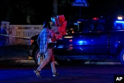 Warga berjalan pulang dari toko lokal saat polisi menutup area di sekitar lokasi penembakan di Gereja Episkopal Saint Stevens di Vestavia, Alabama, 16 Juni 2022. (AP Photo/Butch Dill)