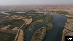This picture taken on June 12, 2022 shows an aerial view of the Tigris river which is witnessing lower levels of water due to climate change and repeated heatwaves. at Hammam al-Alil, south of Iraq's northern city of Mosul. 