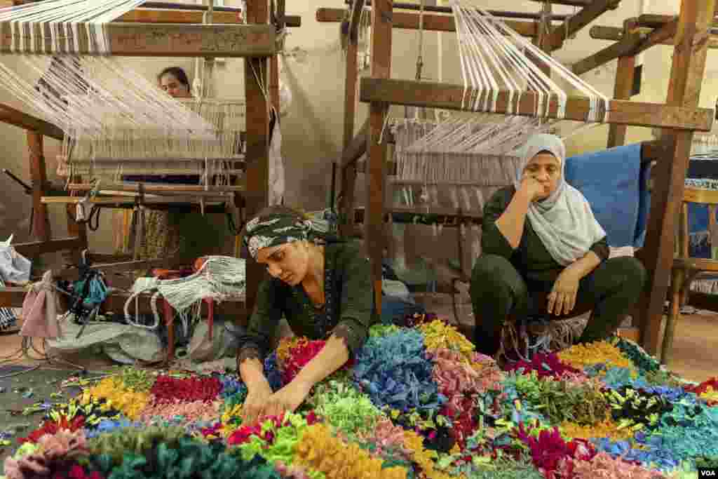 Omu Abanoub, a rug weaver and single mother of two, says even though she only makes an average of $80 a month, she still dreams of opening her own business. She is seen in east Cairo, June 27, 2022.