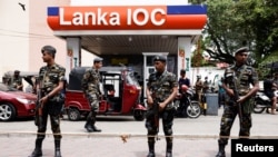 Air Force members stand guard at a Lanka IOC fuel station (Indian Oil Corporation) as people queue up to buy fuel due to fuel shortage, amid the country&#39;s economic crisis, in Colombo, Sri Lanka, July 6, 2022. 