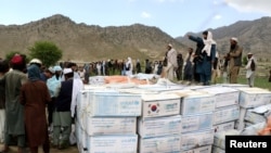 Afghan men gather to collect relief goods after a recent earthquake in Gayan, Afghanistan, June 23, 2022. 