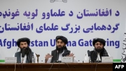 FILE - Taliban spokesman Zabihullah Mujahid, center, speaks during a press conference in Kabul on June 30, 2022.