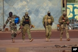 FILE - This undated file photograph issued by French military shows three Russian mercenaries, right, in northern Mali.