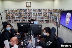 Software engineers work on a facial recognition program that identifies people when they wear a face mask, China, March 6, 2020.