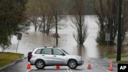 A car blocks access to a flooded street at Camden on the outskirts of Sydney, Australia, on July 4, 2022. More than 30,000 residents of Sydney and its surrounds have been told to evacuate or prepare to do so on Monday, when rain and flash floods are expected.