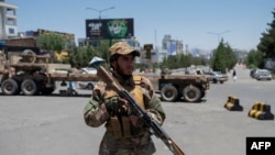 Seorang pejuang Taliban berjaga di sepanjang jalan yang diblokir menjelang pertemuan dewan pemimpin suku dan agama di Kabul pada 29 Juni 2022. (Foto oleh Wakil KOHSAR / AFP)
