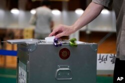 A voter casts a ballot in the upper house elections at a polling station on July 10, 2022, in Tokyo.