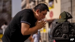 FILE - A man cools off in a fountain during a hot day in downtown Madrid, Spain, June 18, 2022. High temperatures have continued in Spain and are forecast to spread to France and Britain in the coming days. 