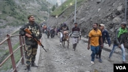An Indian security guard keeps vigil as pilgrims cross mountain trails during their journey to the holy Amarnath cave in India. (Photo by Wasim Nabi)
