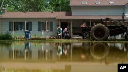 Aileen Rogers, right, and Melody Murter help clean out a friend's house that was badly damaged by the severe flooding in Fromberg, Mont., June 17, 2022.