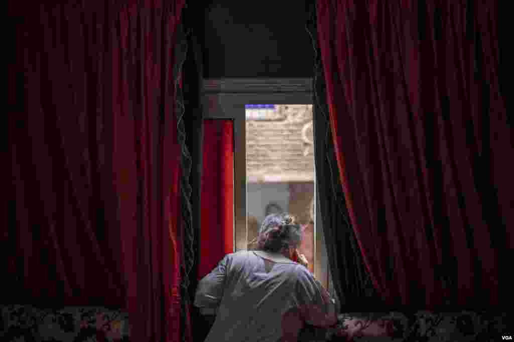 Marina, a stay-at-home mother of two daughters, looks below at the bustling streets of east Cairo, June 26, 2022. "I dream of opening a beauty salon, but I can't find the time and my own financial resources to do so," she said.