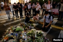 People pay respects at the site where late former Japanese Prime Minister Shinzo Abe was shot while campaigning for a parliamentary election, near Yamato-Saidaiji station in Nara, western Japan, July 8, 2022.