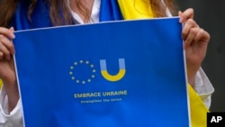Members of the Ukrainian community in Portugal demonstrate outside of the Netherlands embassy in Lisbon in support of Ukraine joining the European Union, June 15, 2022. 