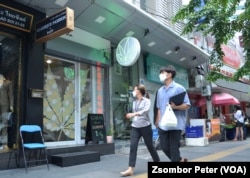 People walk past the Chopaka cannabis shop in Bangkok, Thailand.
