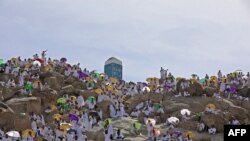 Jemaah haji berkumpul untuk berdoa di puncak Gunung Arafat, juga dikenal sebagai Jabal al-Rahma, tenggara kota suci Saudi Mekah, di saat puncak ibadah haji, pada 8 Juli 2022. (Foto: AFP/Christina ASSI)